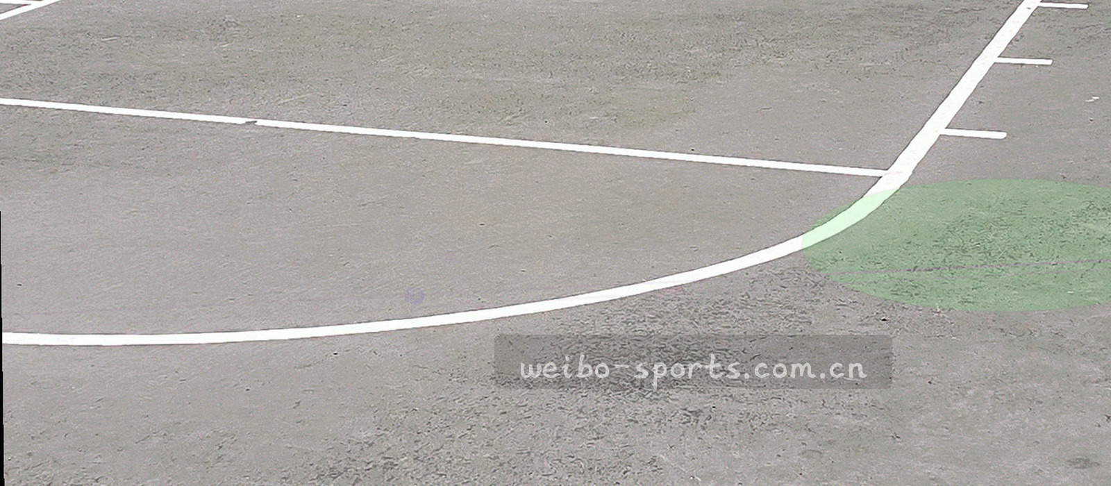 从高处俯瞰的球场边线、跑道与看台结构，画面偏几何切割